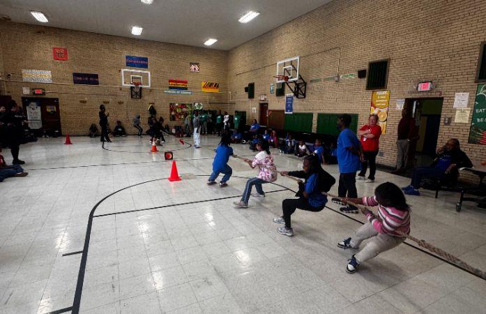  Students playing tug-of-war in gymnasium.